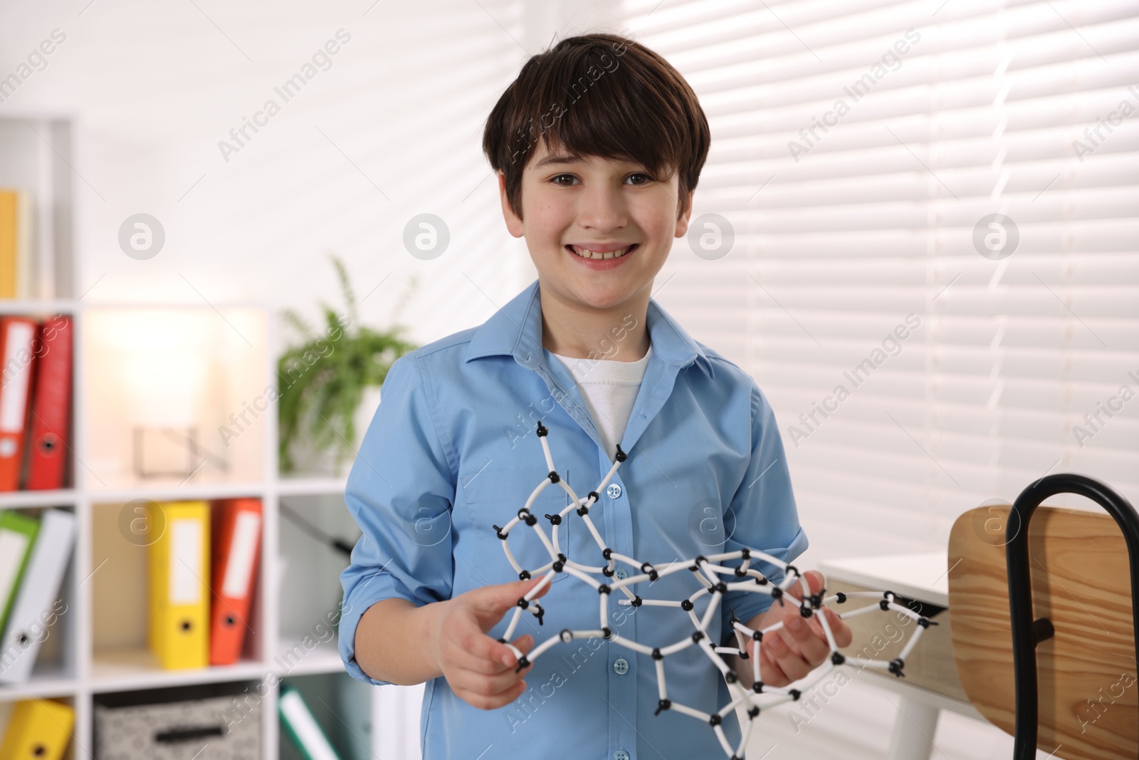 Photo of Smiling boy with DNA structure model indoors