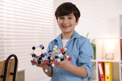 Photo of Smiling boy with DNA structure model indoors