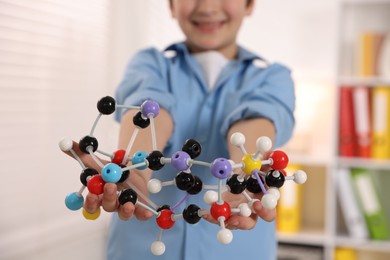 Boy with DNA structure model indoors, closeup