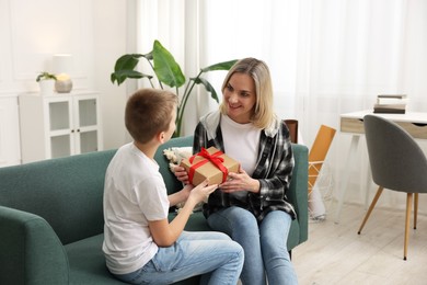 Son giving present to his mom at home