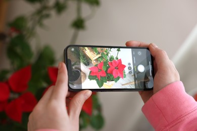 Photo of Woman using houseplant recognition application on smartphone indoors, closeup