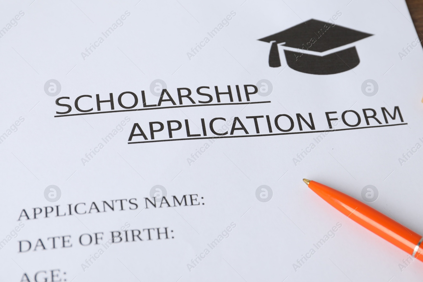 Photo of Scholarship application form and pen on table, closeup