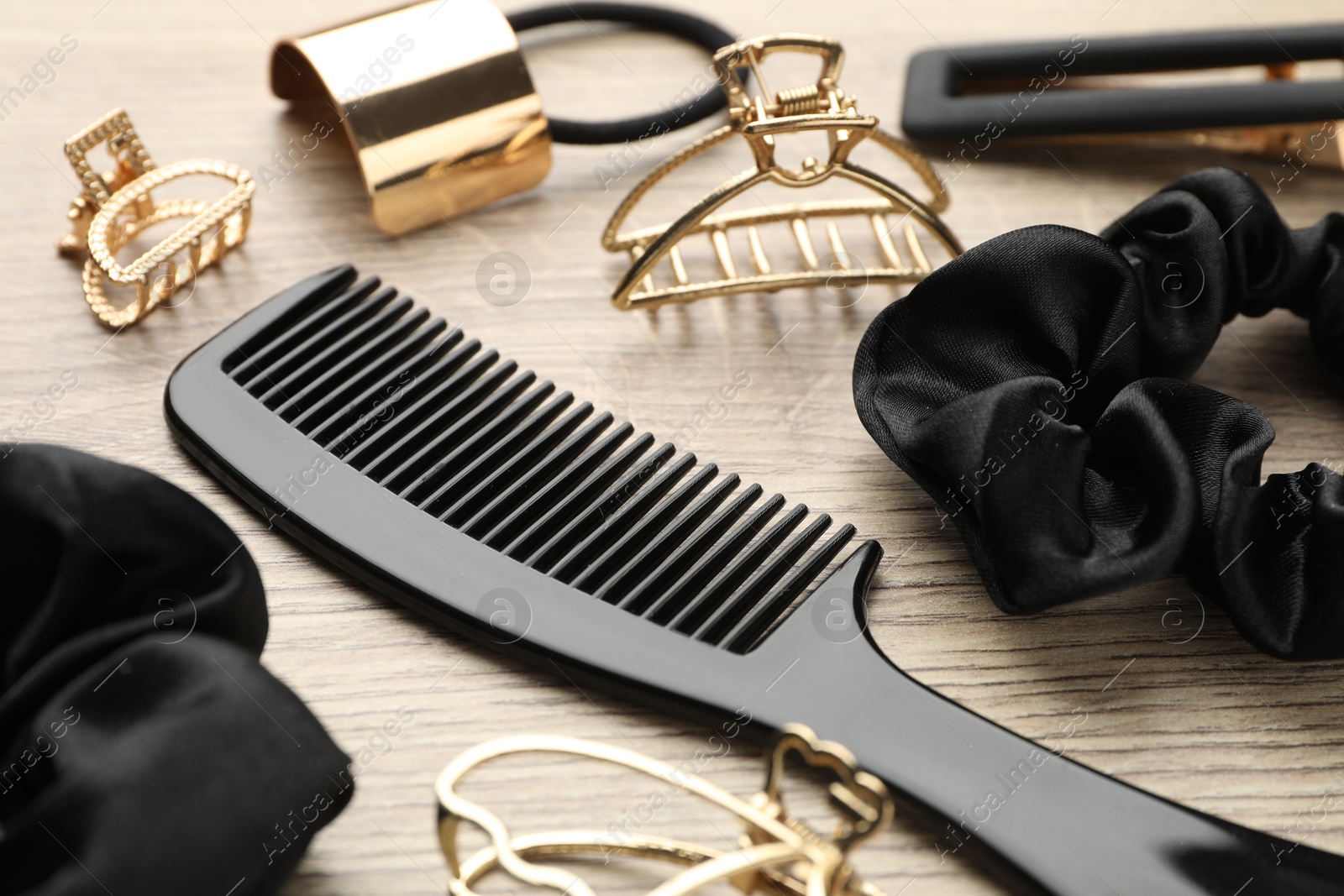 Photo of Different hair accessories on wooden table, closeup