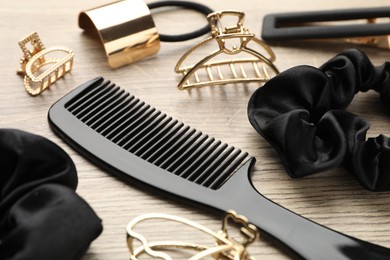 Different hair accessories on wooden table, closeup