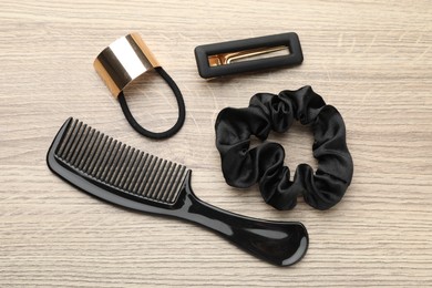 Different hair accessories on wooden table, flat lay