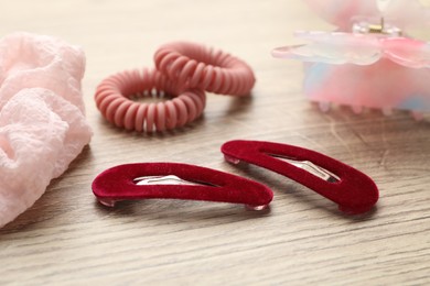 Different hair accessories on wooden table, closeup