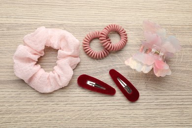 Different hair accessories on wooden table, flat lay