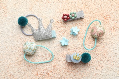 Photo of Different hair accessories on color textured table, flat lay