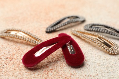 Different hair clips on color textured table, closeup