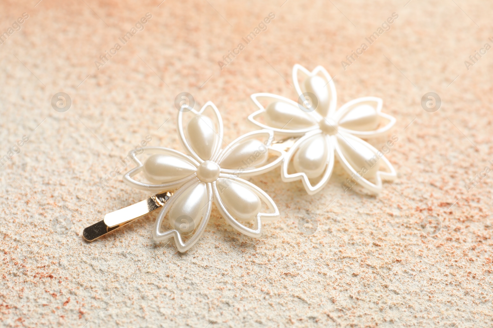 Photo of Beautiful hair clip on color textured table, closeup