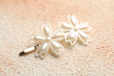 Beautiful hair clip on color textured table, closeup