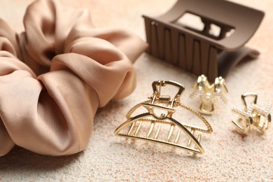 Different hair accessories on color textured table, closeup