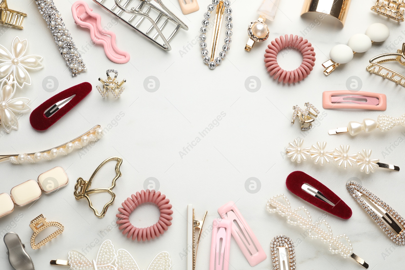 Photo of Frame of different hair accessories on white marble table, flat lay. Space for text