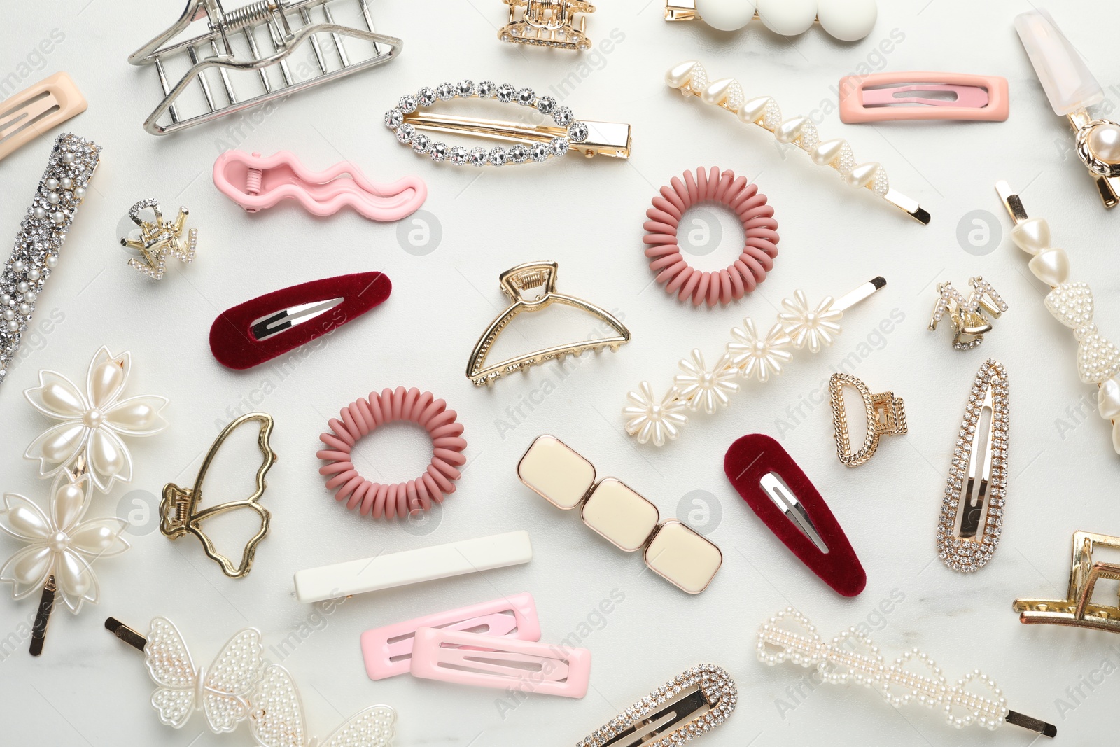 Photo of Different hair accessories on white marble table, flat lay