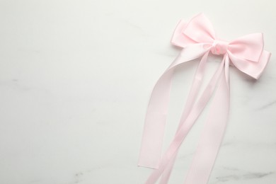 Beautiful hair bow on white marble table, top view. Space for text