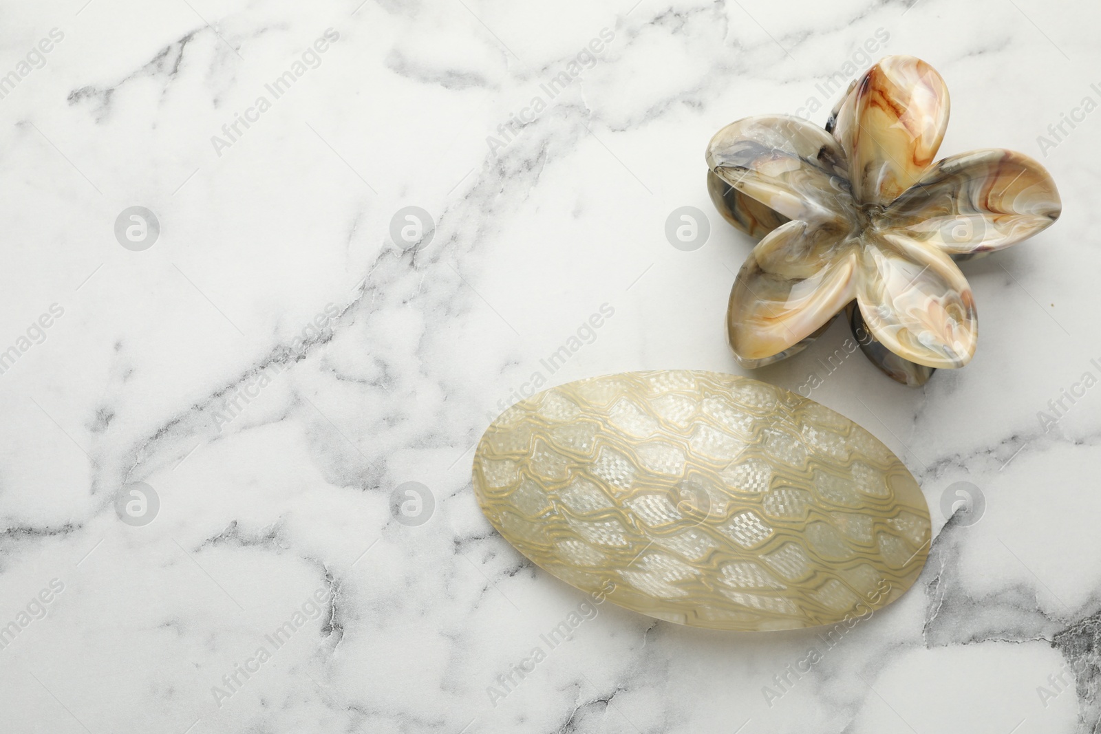 Photo of Beautiful hair accessories on white marble table, flat lay. Space for text