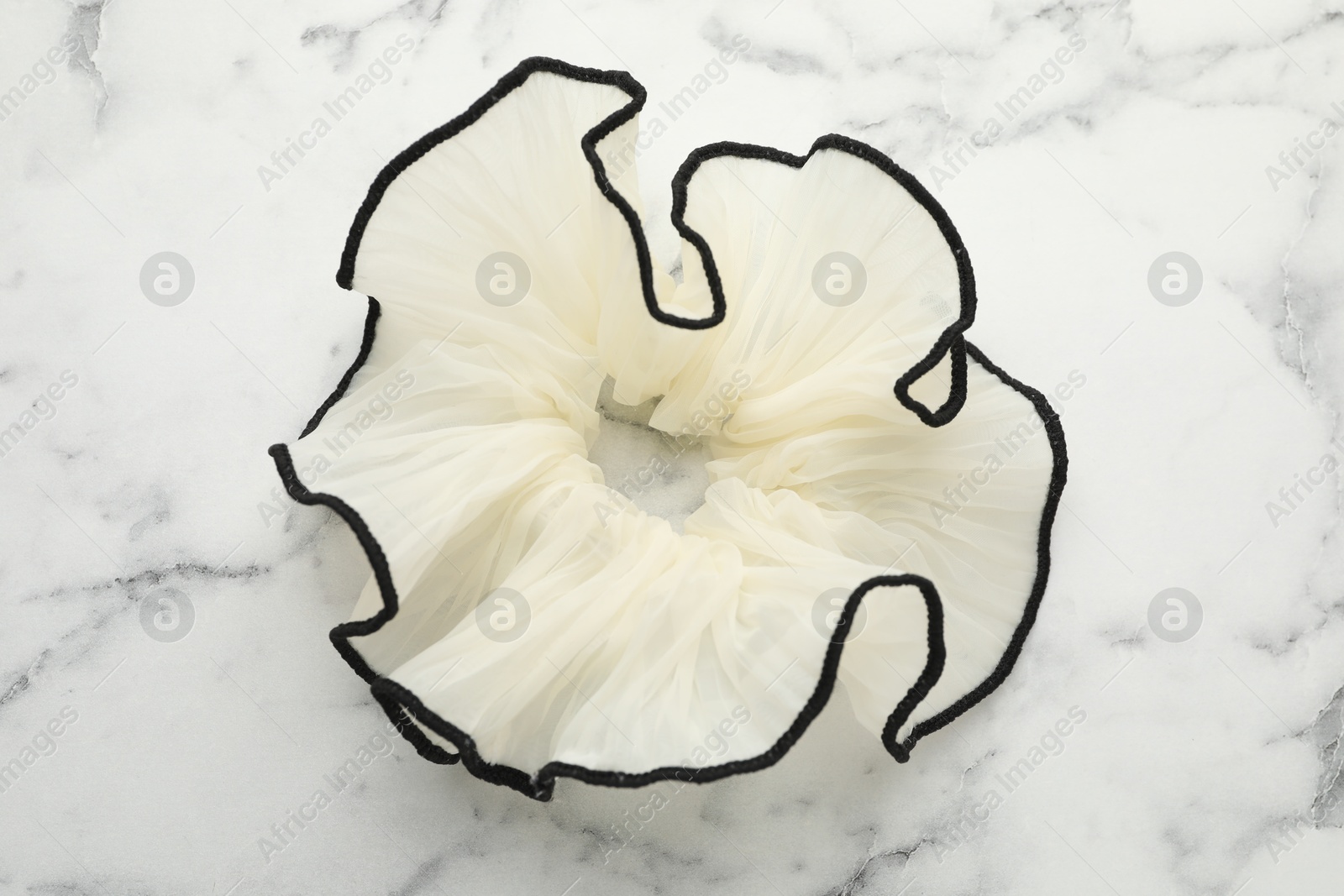 Photo of Beautiful hair scrunchie on white marble table, top view