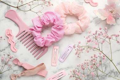 Photo of Different hair accessories and gypsophila flowers on white marble table, flat lay