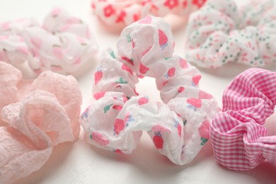 Photo of Different hair scrunchies on white table, closeup