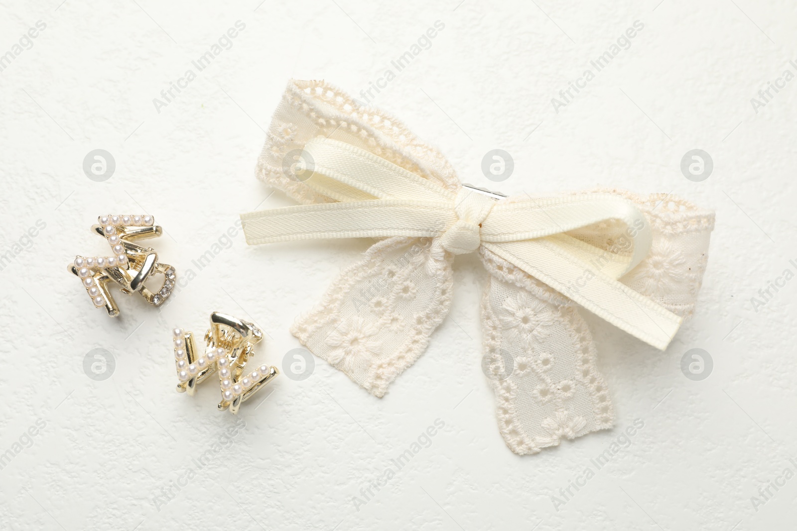 Photo of Hair bow and clips on white table, flat lay