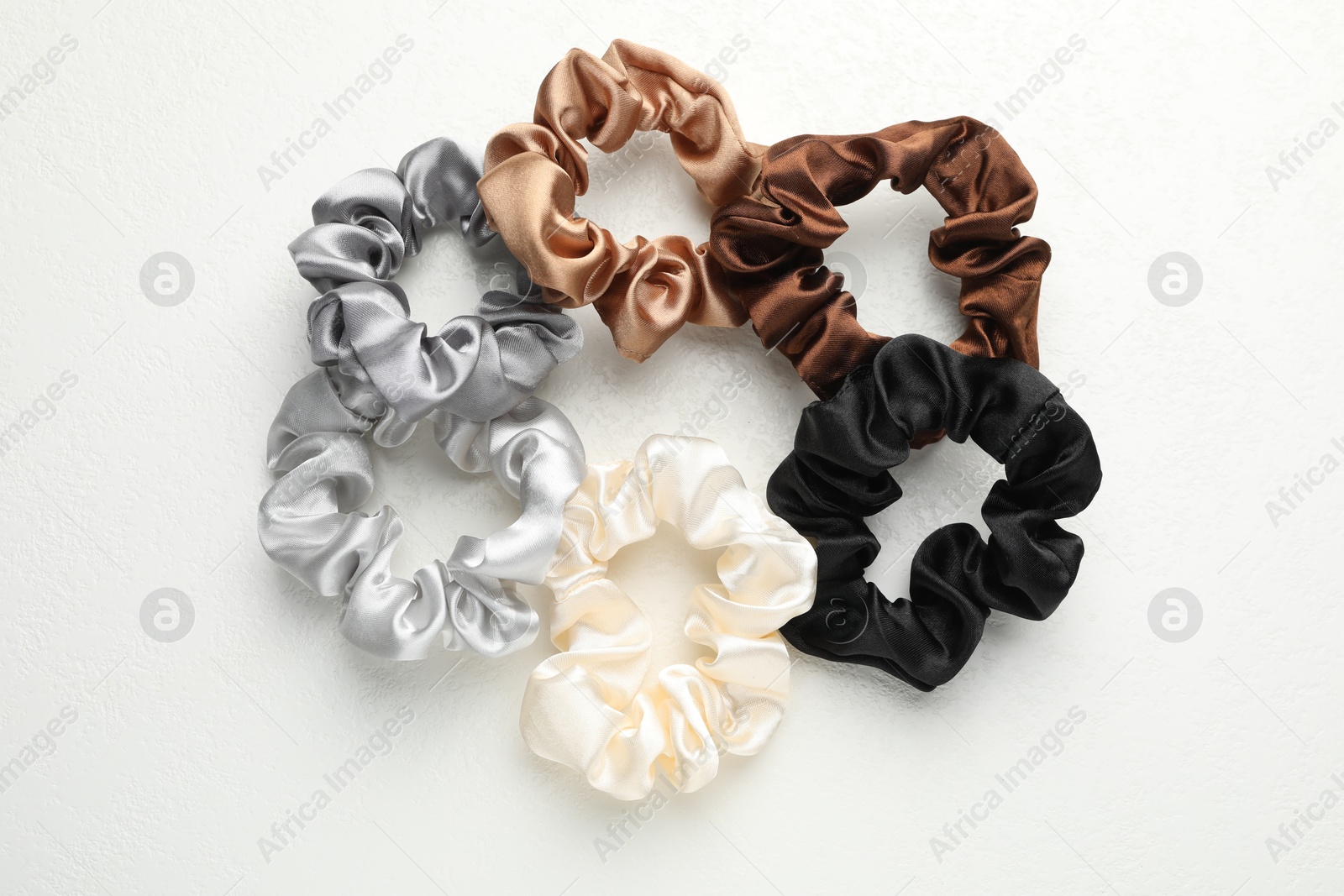 Photo of Different hair scrunchies on white table, flat lay