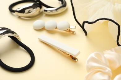 Photo of Different hair accessories on beige background, closeup