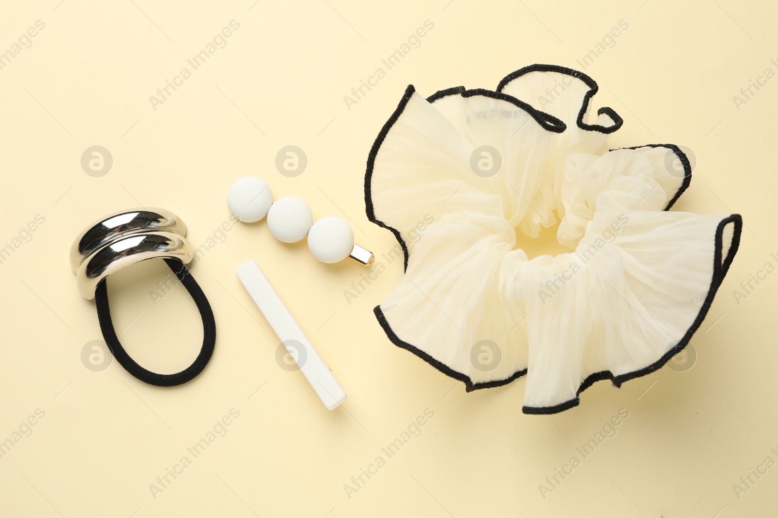 Photo of Different hair accessories on beige background, flat lay