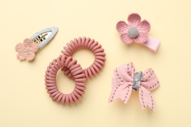 Different hair accessories on beige background, flat lay