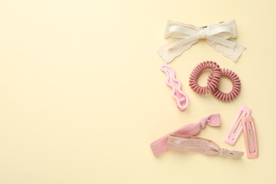 Different hair accessories on beige background, flat lay. Space for text