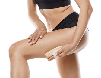 Photo of Woman doing anti cellulite massage with brush on white background, closeup