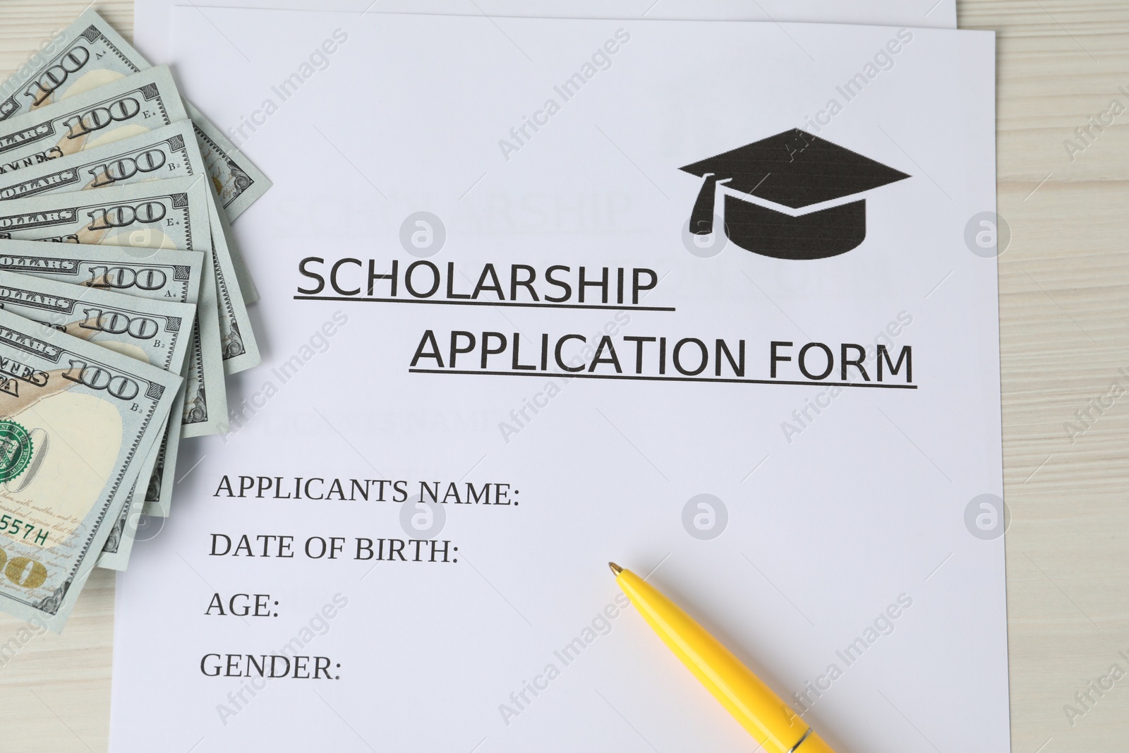 Photo of Scholarship application form, dollar banknotes and pen on wooden table, flat lay