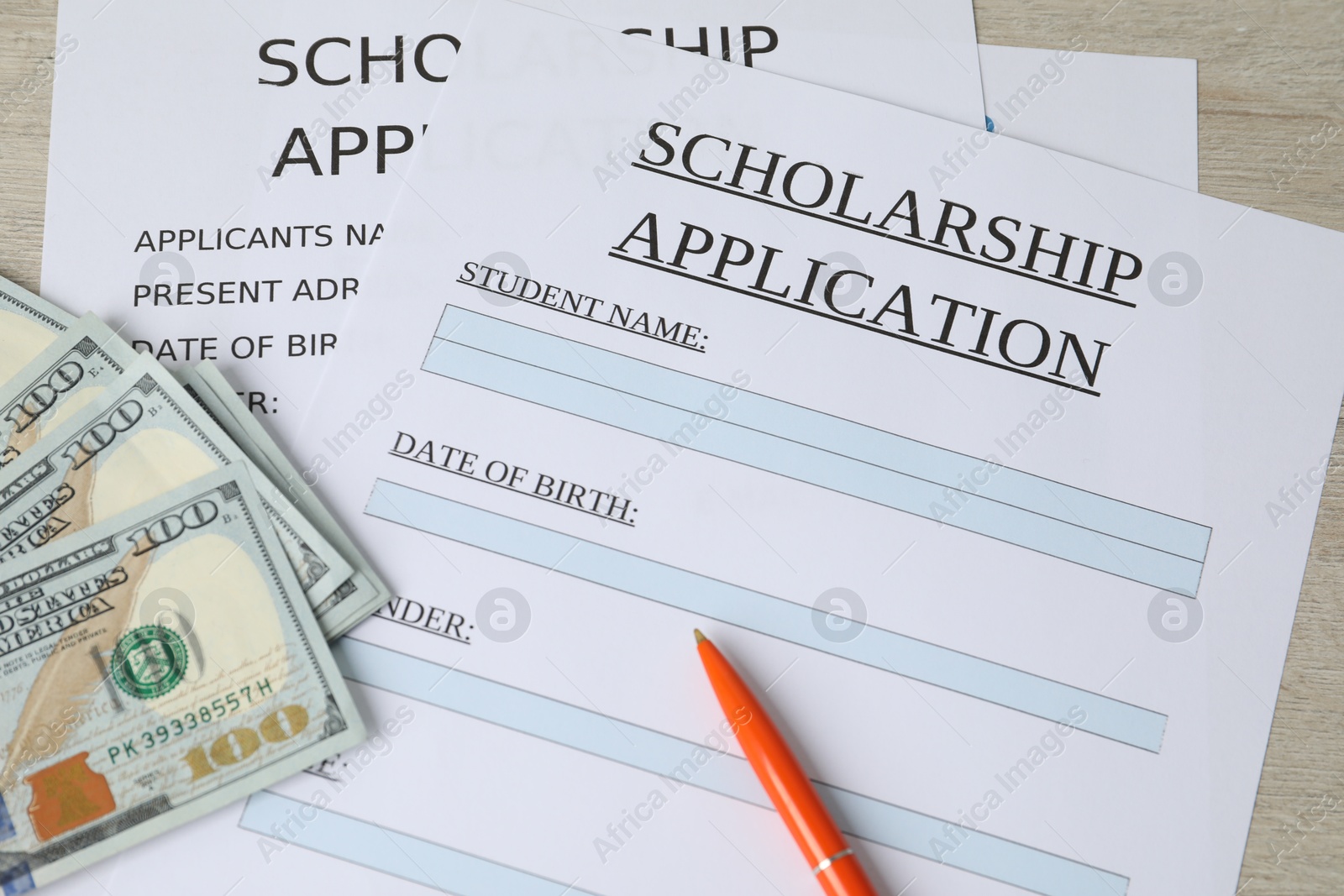 Photo of Scholarship application forms, pen and dollar banknotes on wooden table, above view