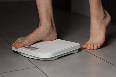 Photo of Woman on scales indoors, closeup. Bulimia problem