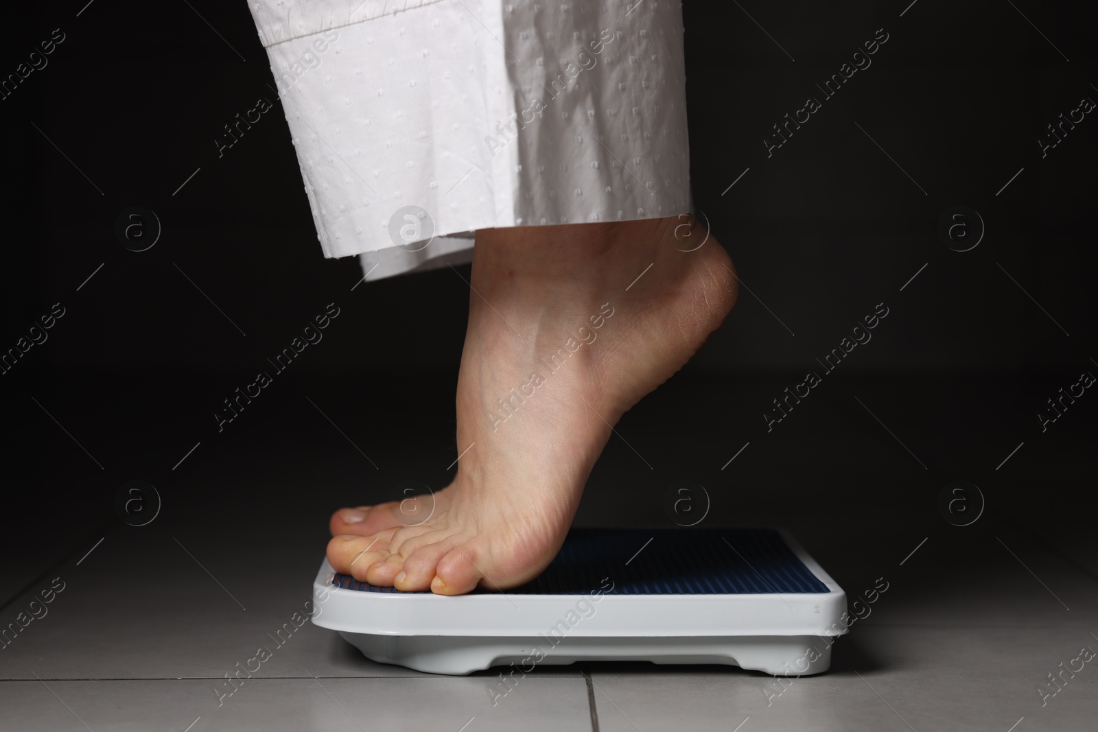 Photo of Woman on scales indoors, closeup. Bulimia problem