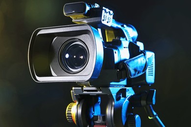 Photo of Modern video camera on black background, closeup