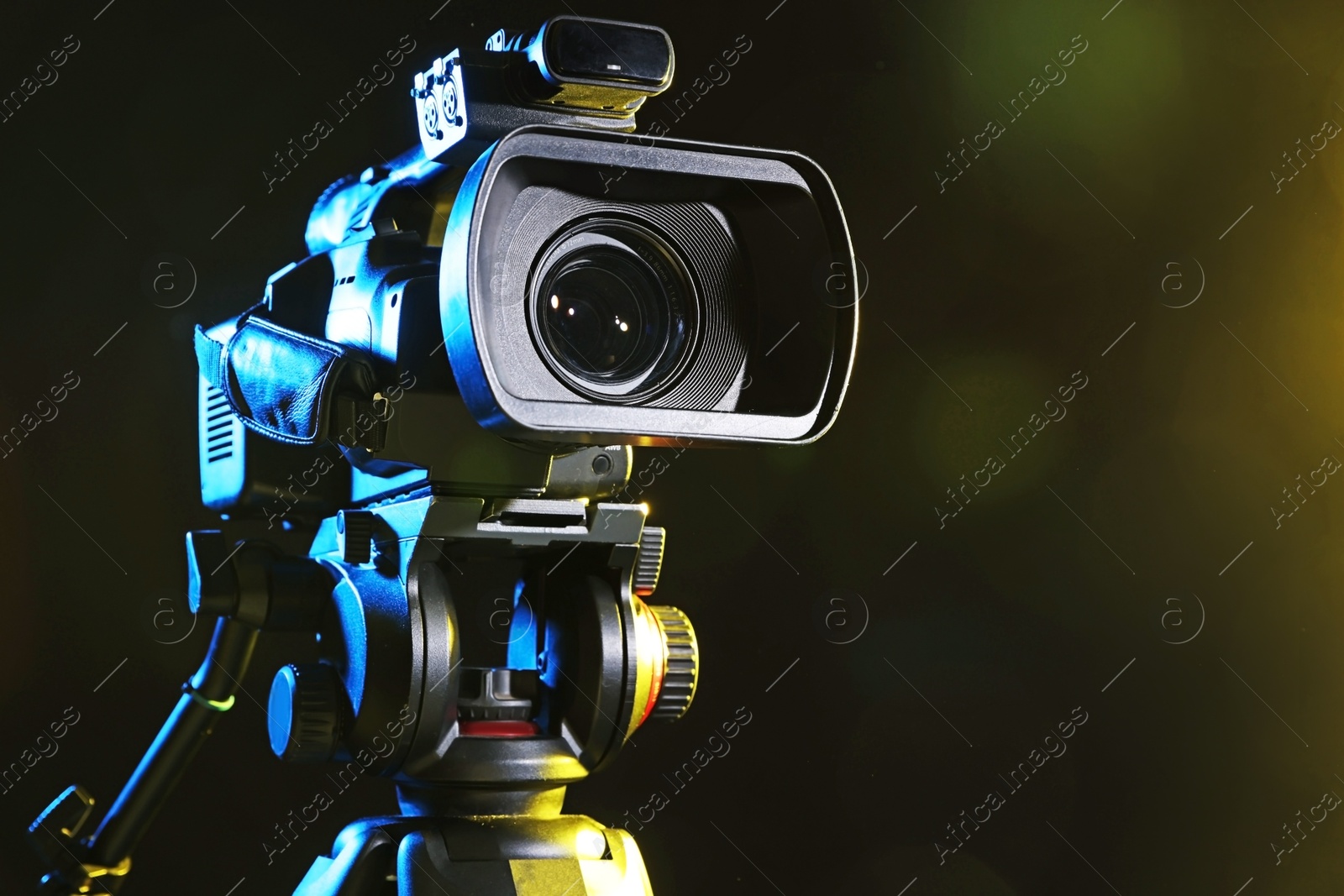 Photo of Modern video camera on black background, closeup. Space for text