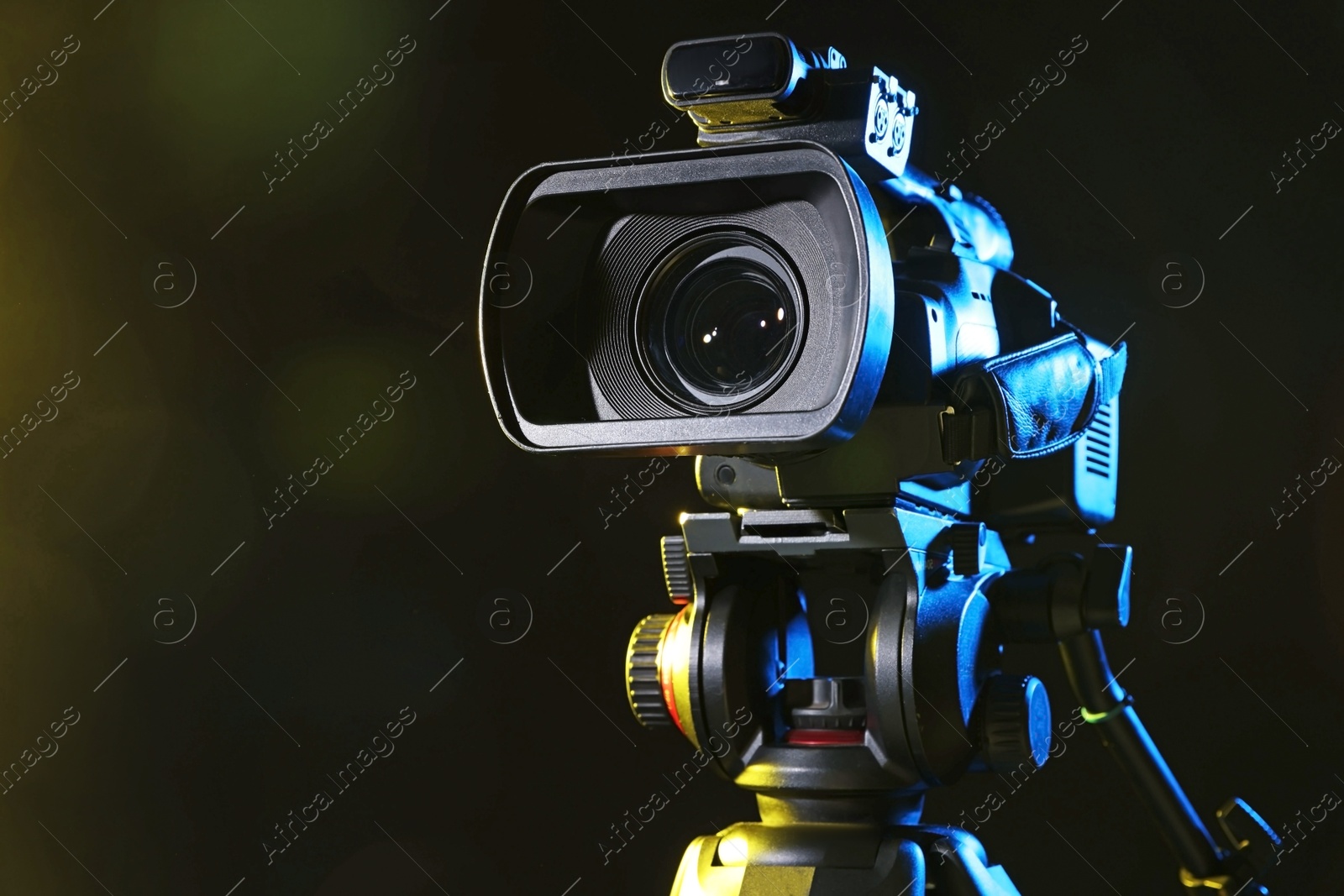 Photo of Modern video camera on black background, closeup. Space for text