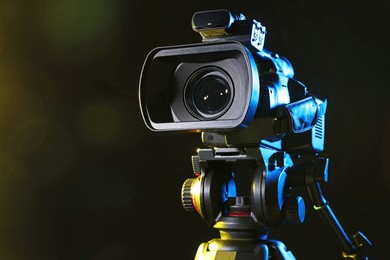 Modern video camera on black background, closeup. Space for text