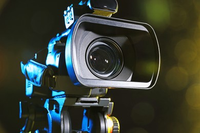 Photo of Modern video camera on black background, closeup