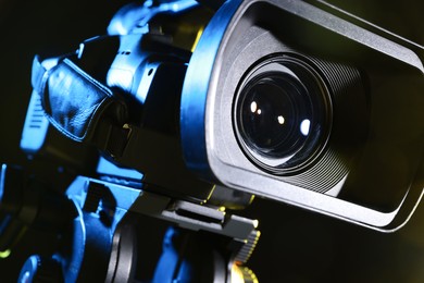 Photo of Modern video camera on black background, closeup