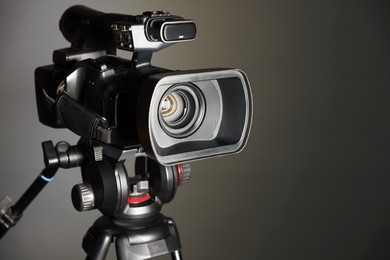 Modern video camera on grey background, closeup. Space for text