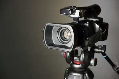 Modern video camera on grey background, closeup. Space for text