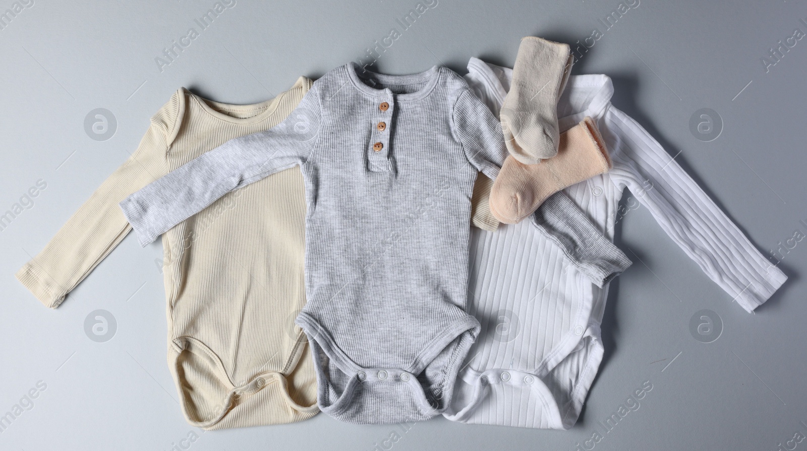 Photo of Baby clothes on light grey background, flat lay