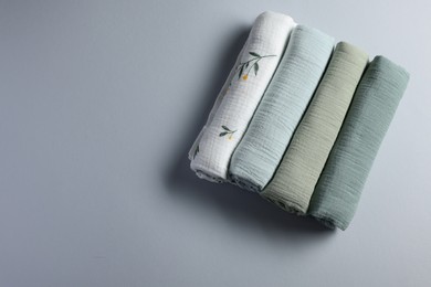 Photo of Rolled baby blankets on light grey background, flat lay. Space for text