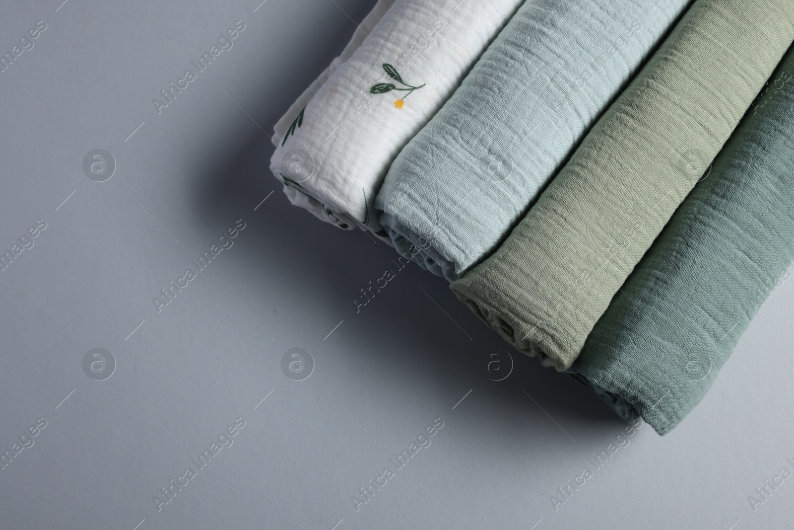 Photo of Rolled baby blankets on light grey background, flat lay. Space for text