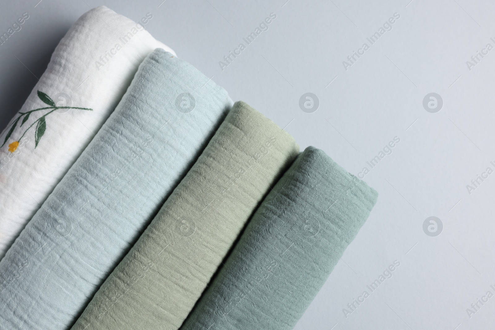 Photo of Rolled baby blankets on light grey background, flat lay