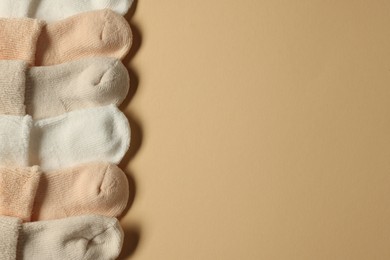 Photo of Baby socks on beige background, flat lay