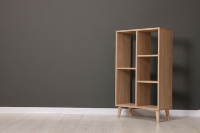 Photo of Empty shelving unit near grey wall indoors, space for text