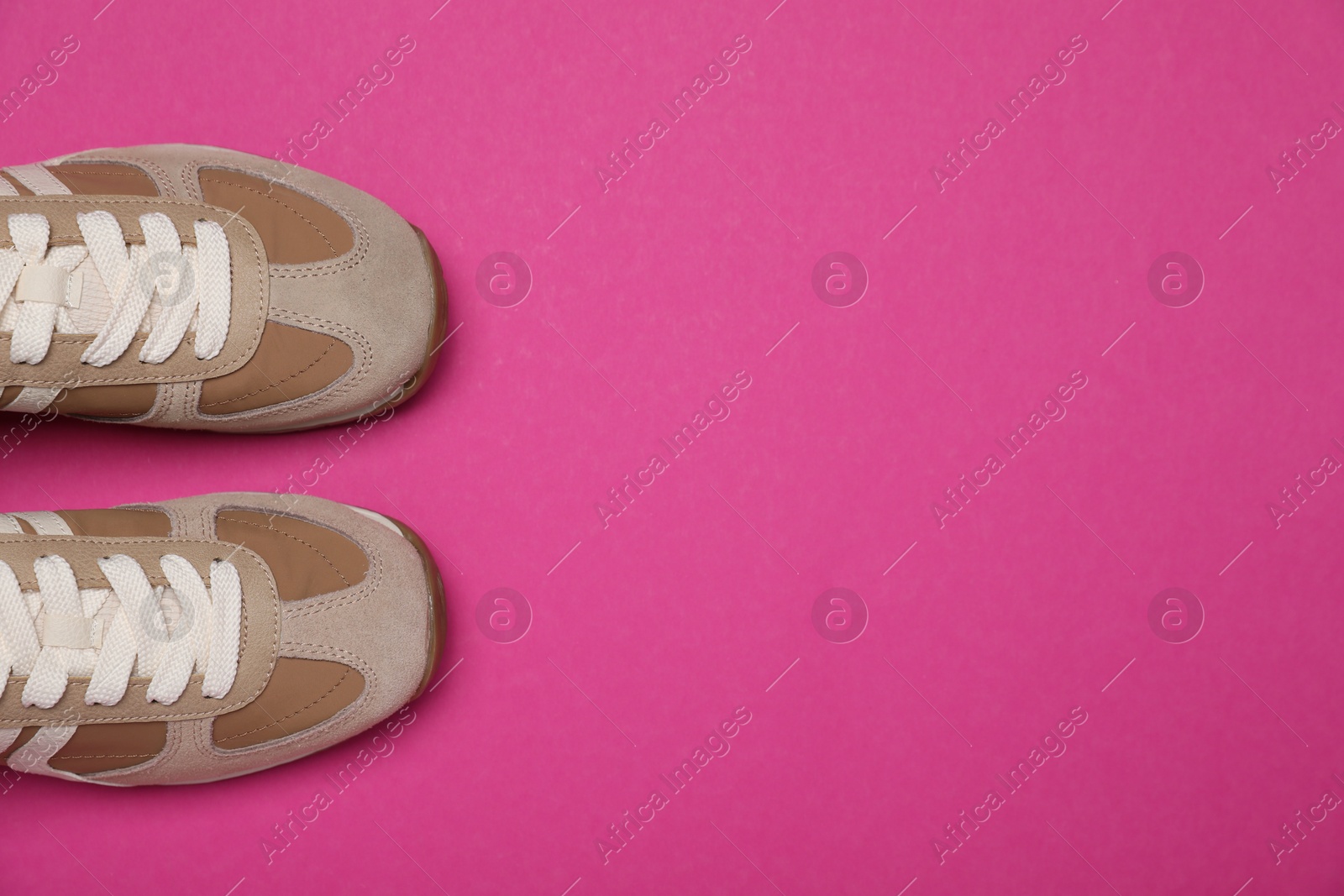 Photo of Casual shoes. Pair of stylish sneakers on bright pink background, flat lay. Space for text