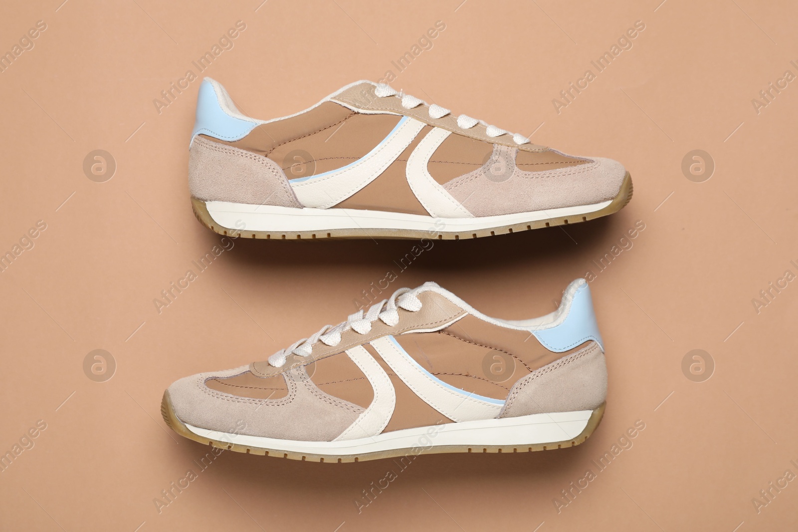 Photo of Pair of stylish sneakers on beige background, flat lay. Casual shoes